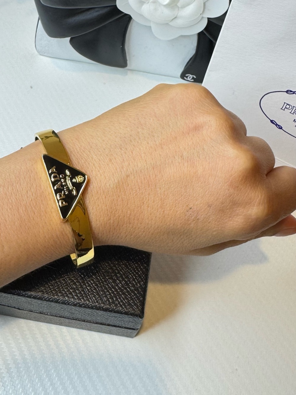 Prada Gold Tone Bangle with Black Triangle Logo Plaque